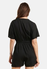 Black short-sleeve romper made of lightweight fabric, featuring a fitted waist, scalloped hem, and a simple design with no patterns.