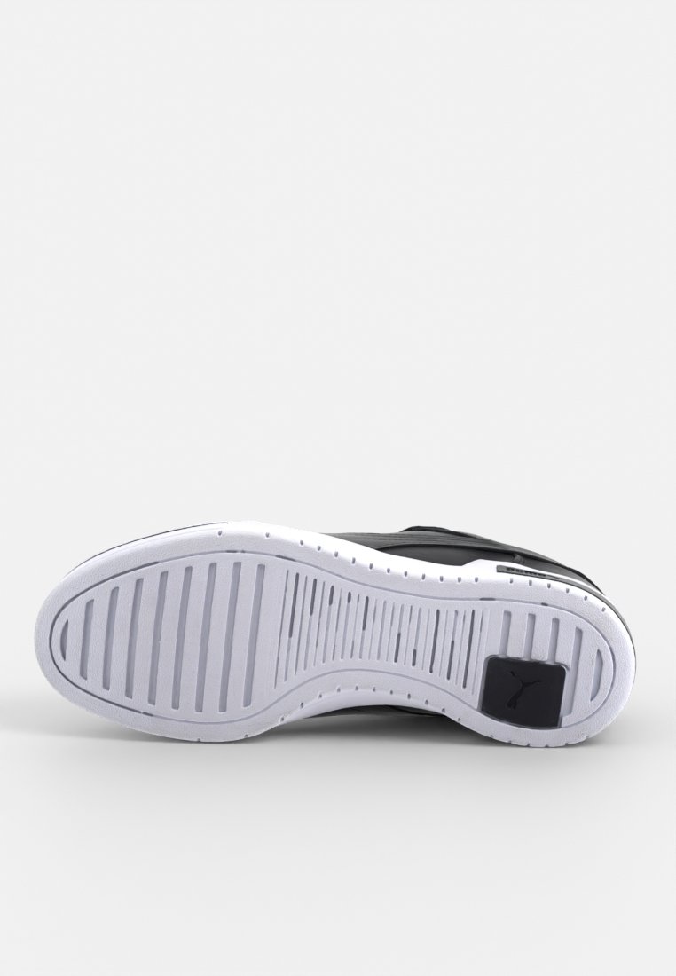 Semelle noire de sneaker avec une semelle extérieure en caoutchouc blanc, texturée avec des rainures parallèles. Présente un logo Puma sur le talon et un design de bout arrondi.