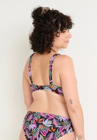 Set bikini con una base nera e vivaci motivi floreali in viola, arancione e verde. Spalline regolabili e chiusura con gancio sulla schiena.