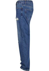 Jeanși din denim albastru deschis cu croială lejeră, având o genunchiere distresată și un design cu cinci buzunare, finalizați cu un bucle tradiționale pentru curea.