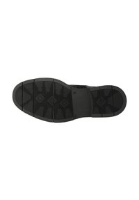 Zool van een zwarte nette schoen met gestructureerde grip patronen en gesegmenteerd profiel op hiel- en teengebieden.