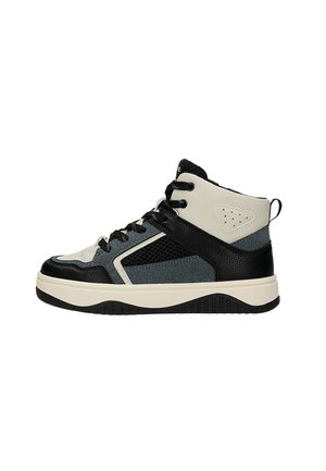 Zapatilla deportiva de tiro alto en negro, gris y blanco con cordones delante, paneles de malla y cuero, suela gruesa y lengüeta en el talón.