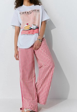 Gray t-shirt with a café graphic featuring cake and coffee. Pink and white checked wide-leg pants. Smooth fabric with a relaxed fit.