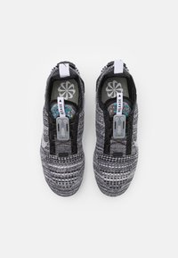 Black and gray knit athletic shoes with a textured upper, elastic laces, and a pull tab; includes colorful insoles and a plastic release mechanism.