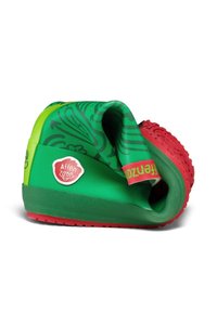 Scarpa flessibile in gomma verde e rossa con tomaia decorata, piegata per mostrare la texture della suola e la toppa laterale con il logo "Affenzahn".