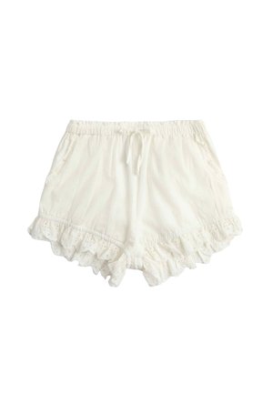 White lightweight cotton shorts with elastic waist, drawstring, side pockets, and ruffled eyelet lace trim on the hems.