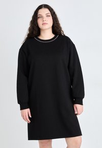 Čierna mikinová šaty s voľným strihom, dlhými rukávmi a okrúhlym výstrihom ozdobeným jemným radom ozdôb.