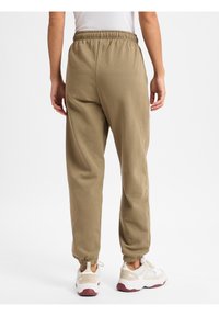 Khaki Jogginghosen mit elastischem Bund und Bündchen, aus weichem Stoff gefertigt. Bieten eine lockere Passform und minimale Details.
