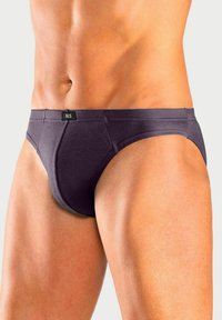 Lila Baumwollunterhosen mit einem niedrigen Bunddesign, ausgestattet mit einem Etikett am Bund und einem glatten, dehnbaren Stoff.