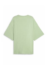 T-shirt oversize verde chiaro realizzato in morbido cotone, con maniche corte e scollatura rotonda. Texture liscia con un design minimalista.
