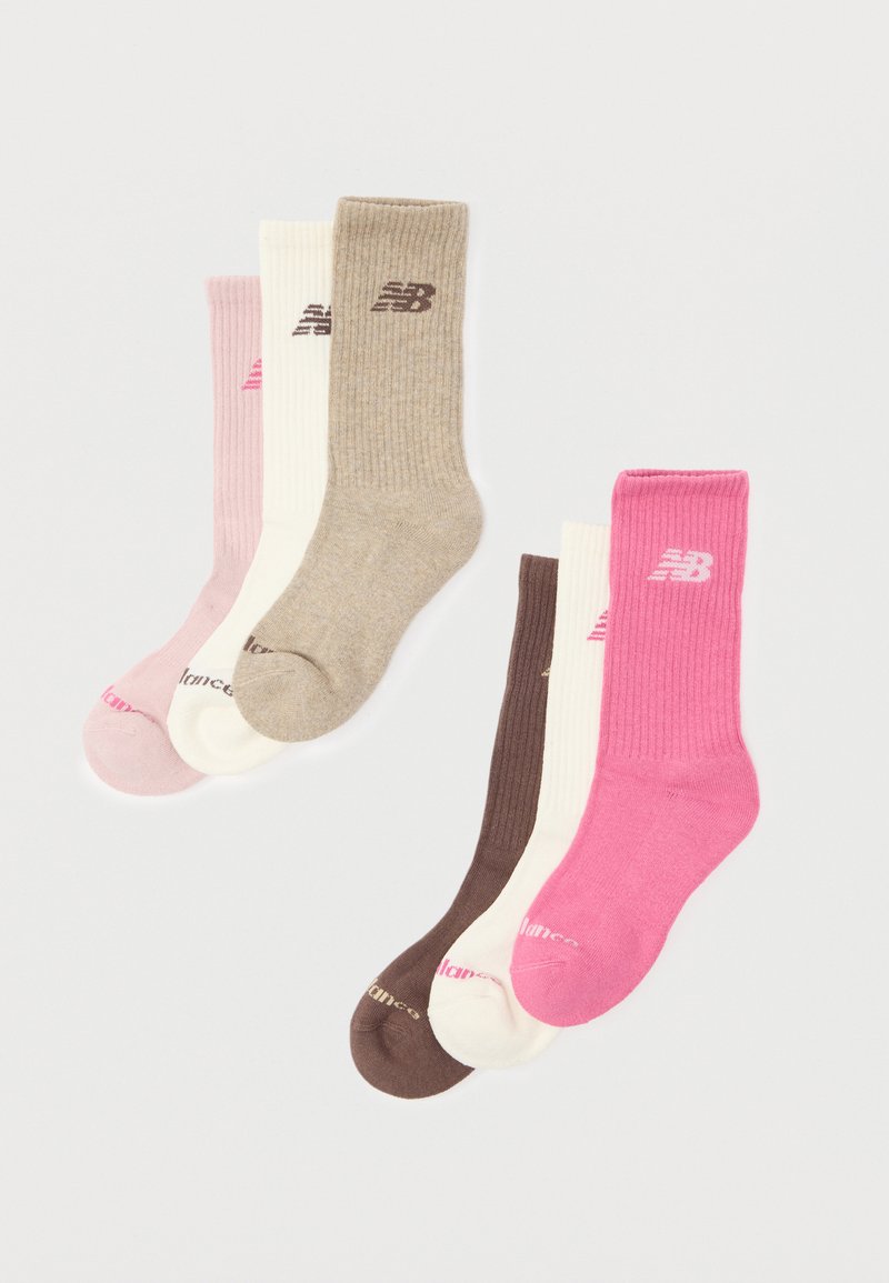Six paires de chaussettes montantes côtelées en rose, beige, blanc et nuances de brun, chacune arborant le logo New Balance près du haut.