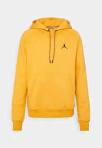 Sudadera amarilla hecha de tela suave, con un bolsillo tipo canguro, capucha con cordón y rayas negras y rojas, y logo de Jordan en negro en el pecho.