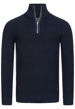 Granatowy sweter robiony na drutach z wysokim kołnierzem i ćwiartkowym zamkiem błyskawicznym. Posiada żebrowaną teksturę i dopasowane rękawy. Dyskretne logo po boku.