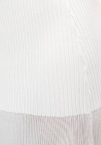 Λευκό ριμπ ύφασμα με υφή, που διαθέτει οριζόντιες ρίγες. Το υλικό μεταβαίνει σε απαλό ανοιχτό γκρι στο κάτω μέρος.