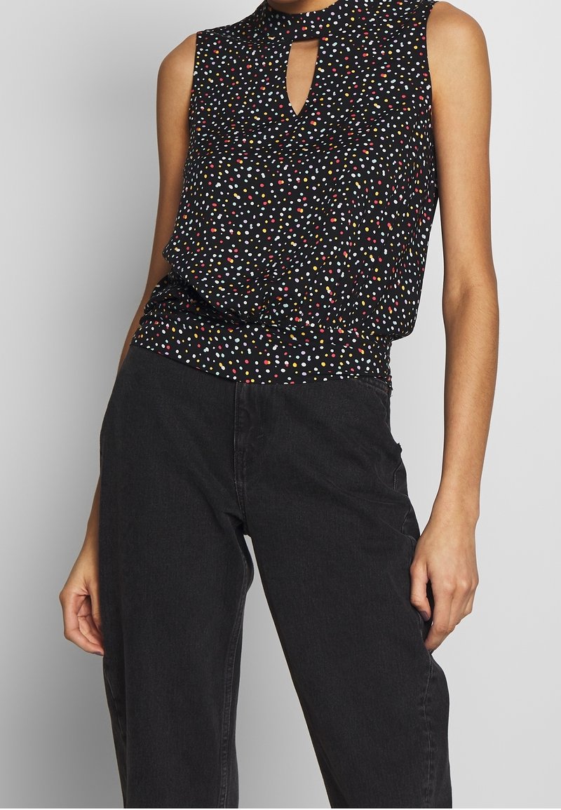 Top nero senza maniche con scollatura a chiave e pois multicolori, caratterizzato da una vestibilità comoda e una vita arricciata.