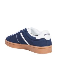Marineblaue Leinensneaker mit weißen Akzenten, Gummisohle, Schnürverschluss und gepolstertem Kragen. "Creeks"-Logo auf der Ferse.