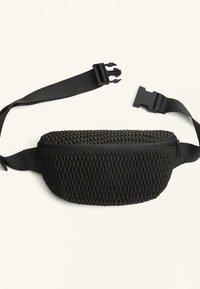 Borseta neagră cu o suprafață texturată în model de diamant, închidere cu fermoar și curea ajustabilă cu o cataramă din plastic.