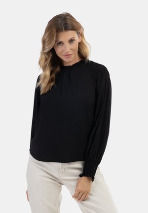 Zwarte blouse met lange mouwen, voorzien van een gathered halslijn en manchet, gemaakt van zachte stof. Kenmerken zijn geplooide details op de schouders en een relaxed fit.