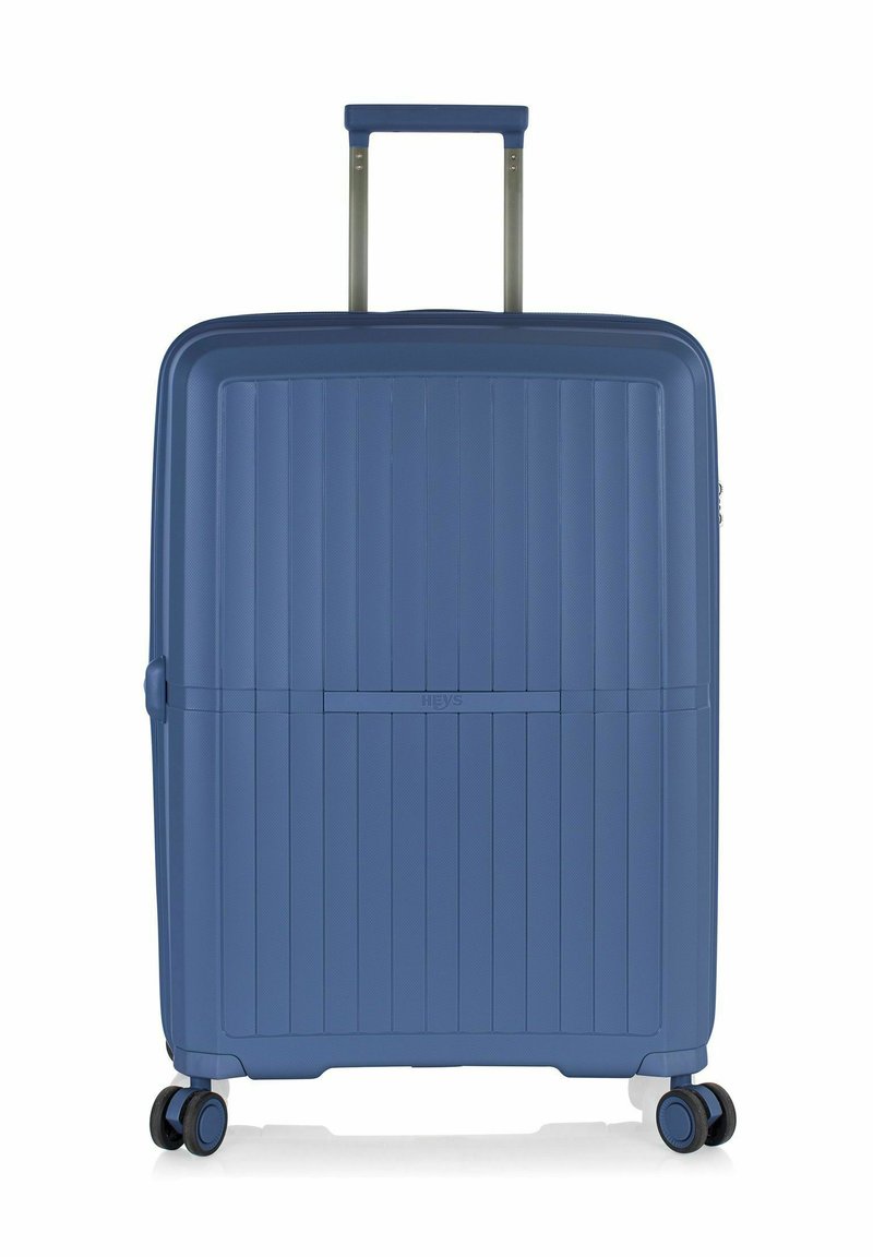 Valigia rigida di colore blu intenso, caratterizzata da un design a righe testurizzate, manico retrattile e ruote scorrevoli per un facile trasporto.