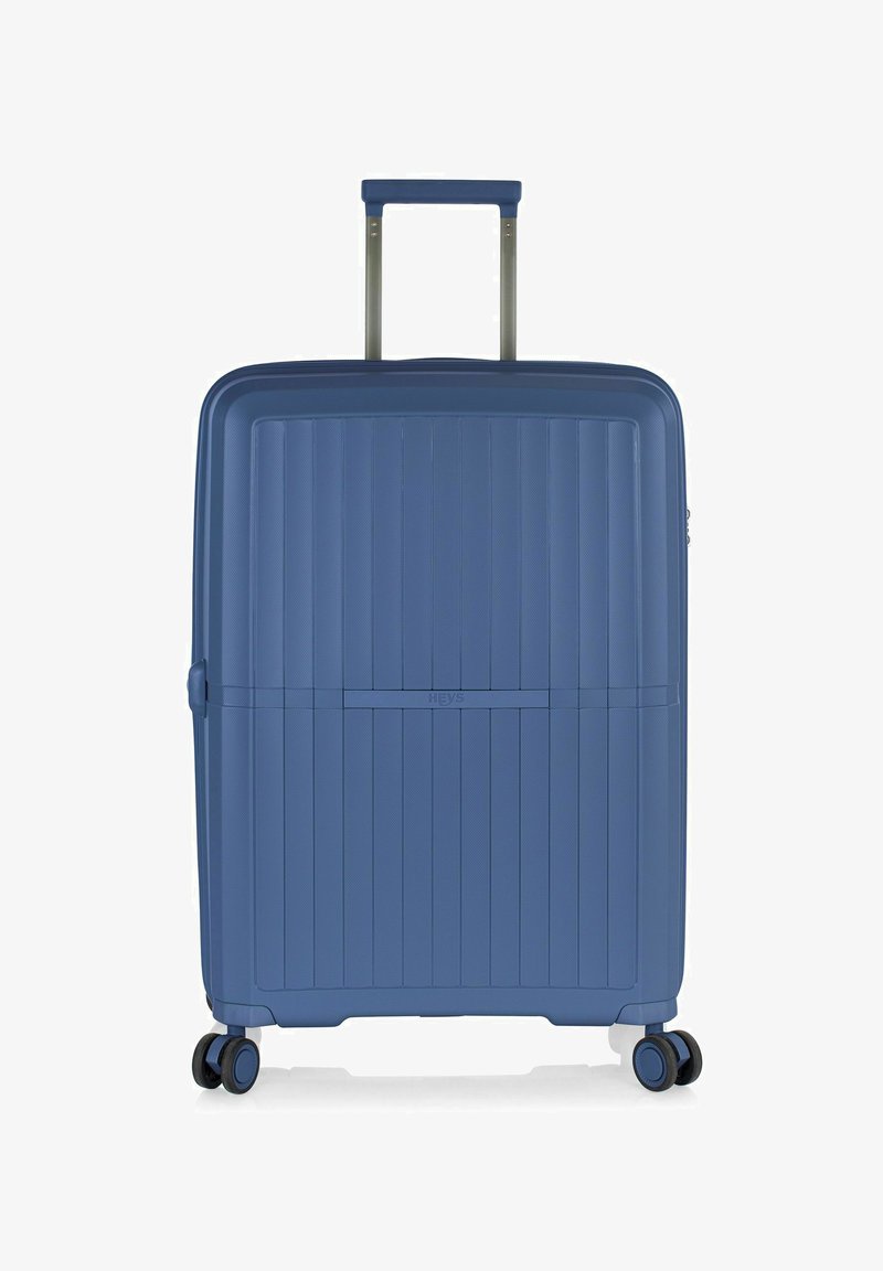 Valigia rigida di colore blu intenso, caratterizzata da un design a righe testurizzate, manico retrattile e ruote scorrevoli per un facile trasporto.