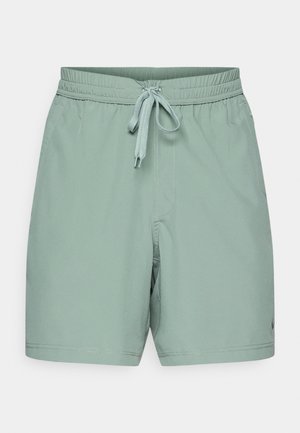 Lys grønne badeshorts laget av et glatt, lett materiale. Har elastisk liv med snøring og sidelommer.