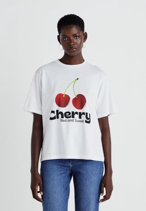 T-shirt en coton blanc avec un graphique de deux cerises rouges et le texte "Cerise Rouge et Douce" en typographie noire en gras.