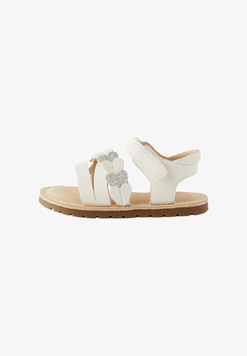 Sandales blanches à trois brides, ornées d'un accent en forme de cœur pailleté. Semelle intérieure douce et semelle extérieure en caoutchouc pour un confort optimal.