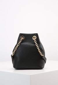 Borsa a secchiello in pelle nera con finitura testurizzata, tracolle in catena color oro e dettagli in eyelet, con fondo arrotondato e apertura superiore.