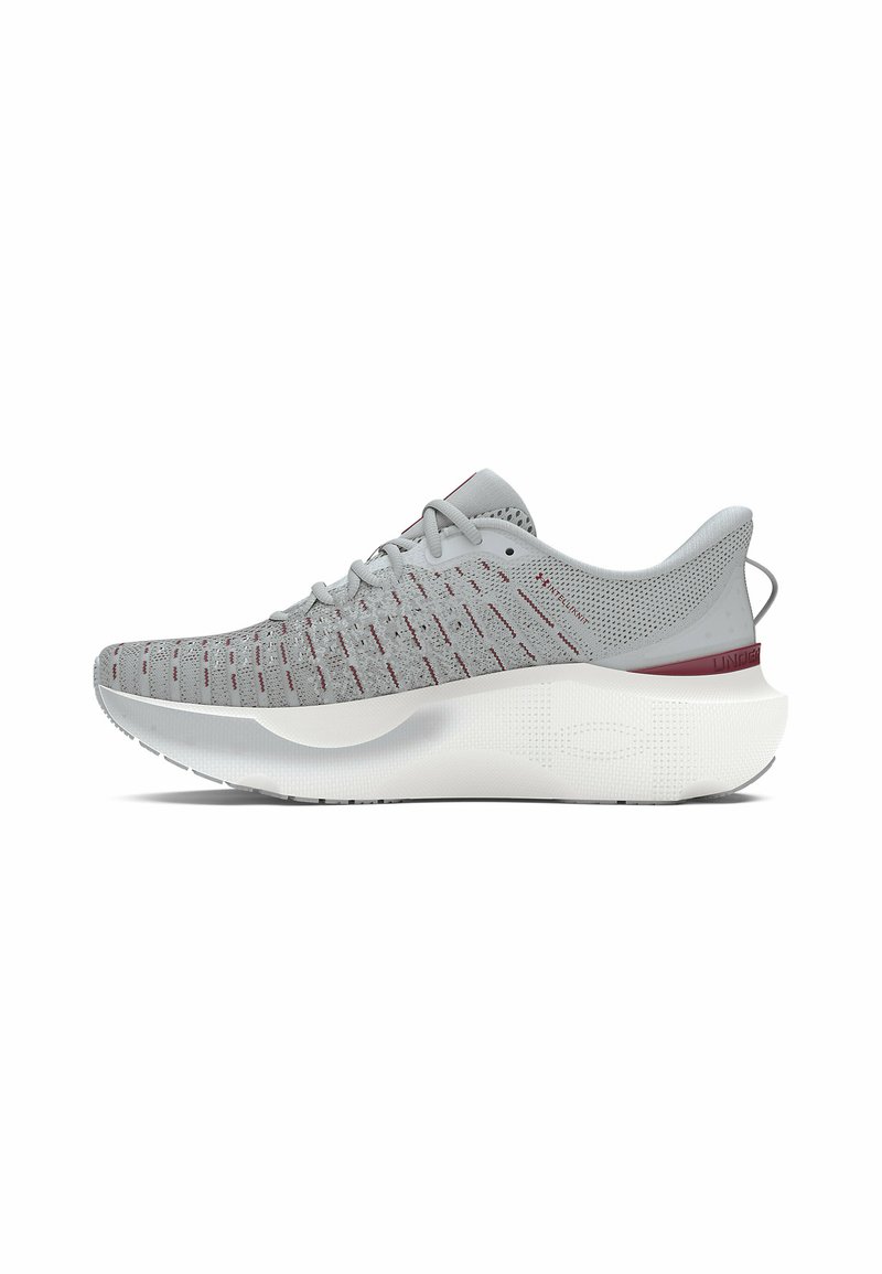 Zapatilla de correr gris con parte superior de malla que presenta detalles rojos, una suela blanca gruesa y un diseño texturizado para mejorar el agarre.