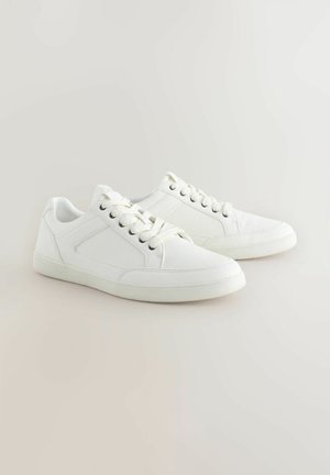 Fehér sneaker, sima bőrből készült, lapos gumitalppal, kerek orral és fűzős kialakítással, beépített fűzőlyukakkal és hálós díszítéssel.