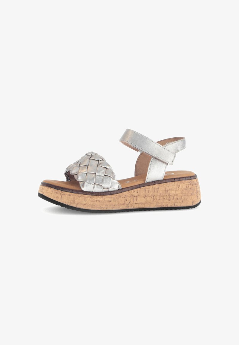 Silver woven strap sandal with a cork wedge sole, featuring an adjustable ankle strap and smooth leather finish.