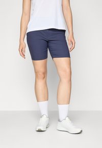 Navy blue athletic shorts made of stretchy fabric, featuring a fitted cut. Paired with white socks and sneakers, with a simple white top.