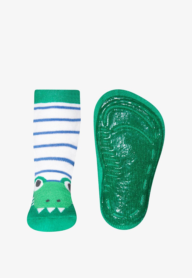 Grün-weiße, gestreifte Socke mit einem Froschgesicht-Design. Die Sohle ist einfarbig grün mit einer strukturierten, rutschfesten Oberfläche.