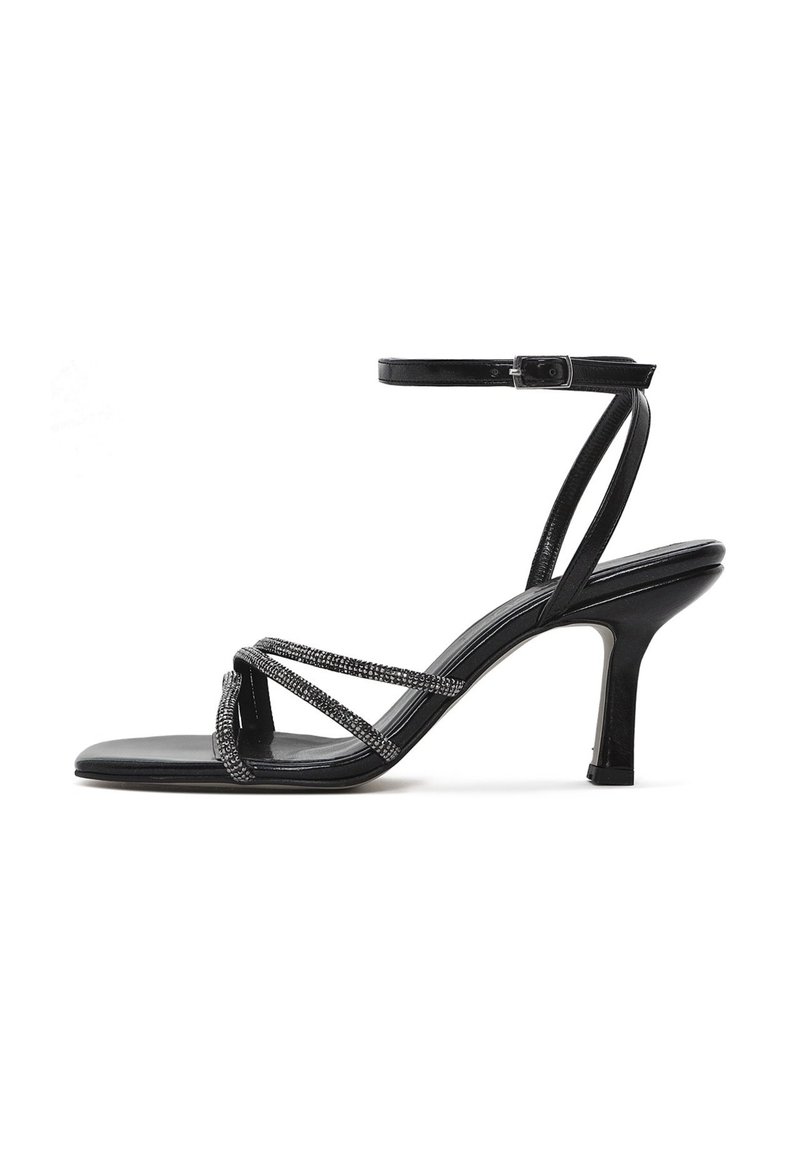 Black high-heeled sandal with an open toe, featuring crisscrossed straps adorned with small beads and an adjustable ankle strap.