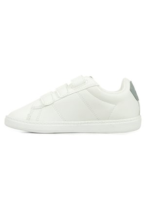 Sneakers synthétiques blancs avec trois sangles en Velcro, bout arrondi, accents texturés et semelle en caoutchouc à motifs. Détails gris subtils au niveau du talon.