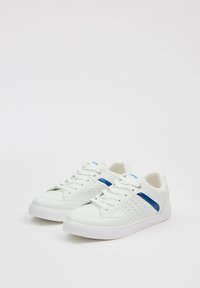 Zapatillas deportivas blancas con acentos azules, detalles perforados en los laterales, punta redondeada y suela de goma blanca. Diseño clásico con cordones.
