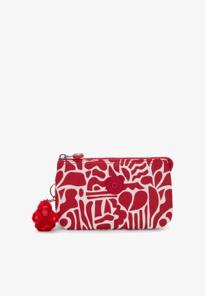 Rood-wit portemonnee met een patroon van abstracte vormen, een ritssluiting en een pompon aapje als bedel aan een metalen sleutelhanger.