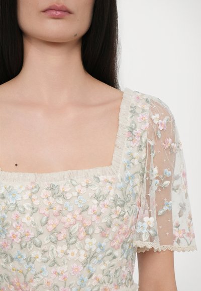 Geborduurd jurkje met een vierkante halslijn, korte doorzichtige mouwen, bloemenpatronen in roze en blauw op een crèmekleurige stof, delicate kantafwerking.