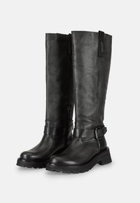Bottes noires en cuir montantes avec une surface texturée, semelles en caoutchouc noir robustes, et détail de sangle avec une boucle en métal. Fermeture éclair latérale.