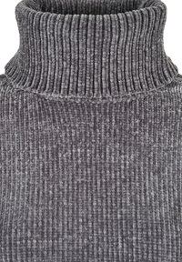 Hallhalli turtleneck, millel on vertikaalne ribikujundus, kõrge krae ja pehme tekstuur, sobib jahedamateks ilmadeks.