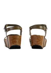 Sandales en liège brun avec une sangle mate marron et des fermetures à boucles. Le talon compensé est texturé pour une meilleure adhérence. Vue de l'arrière.