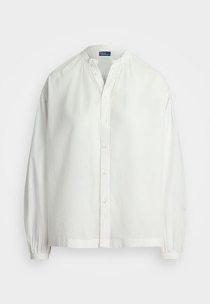 Hvid bluse med lange ærmer med bandkrave, knaplukning foran, rynket skulderstykke og elastiske manchetter, vist på en enkel baggrund.