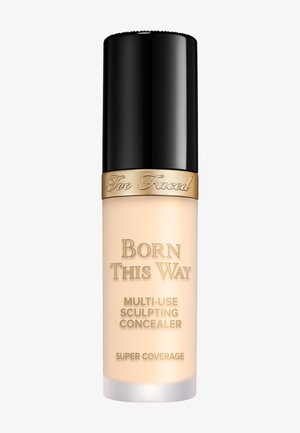 Too Faced Born This Way Multi-Use Sculpting Concealer in een doorzichtige glazen fles met een zwarte dop en gouden accenten, met een gladde crèmetextuur.