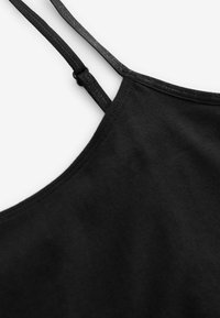Mustern väga õhuke ja reguleeritavate rihmadega must tank top. Sile tekstuur ja keha lähedane disain, millel on ümardatud kaelus ja ilma kaunistusteta.