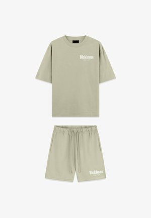 Licht olijfgroene katoen t-shirt met korte mouwen en bijpassende shorts. Bevat witte logo-tekst op beide items. Elastische tailleband op de shorts.