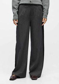 Wide-legged trousers in dark gray fabric with a textured finish. Features side pockets, a tailored waistband, and minimal pleating.