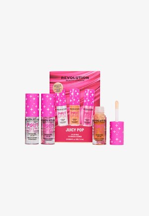Trois tubes à bouchon rose et une huile à lèvres ouverte avec applicateur, près d’un emballage rose portant l’étiquette Revolution Beauty London Juicy Pop lip oils.