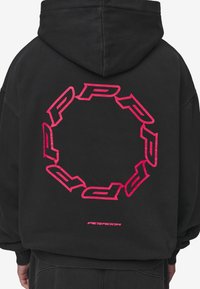 Felpa con cappuccio nera con una grande grafica circolare rosa audace e logo sul retro. Il materiale è morbido con un design a vestibilità rilassata.