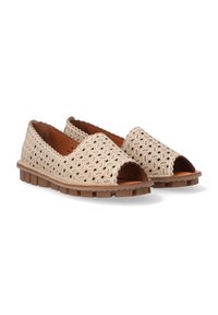 Chaussures beiges ouvertes à l'avant avec des motifs découpés, dessus en synthétique texturé et semelle en caoutchouc marron épaisse. Accentué de bords festonnés.