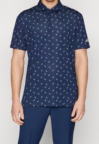 Tmavě modrá polokošile s geometrickým světle modrým vzorem, krátkými rukávy a límečkem. Vyrobena z texturované látky. Logo značky na rukávu.